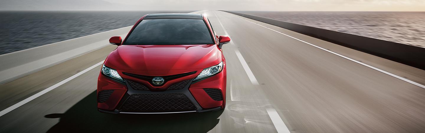Straight on View of Red 2020 Toyota Camry Driving on Open Highway