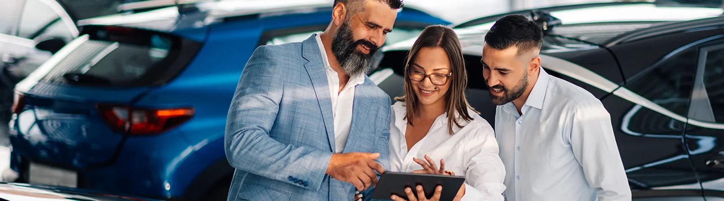 Salesperson showing information to customers about a used vehicle