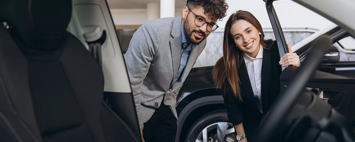 Car salesman showing a customer the interior of a vehicle