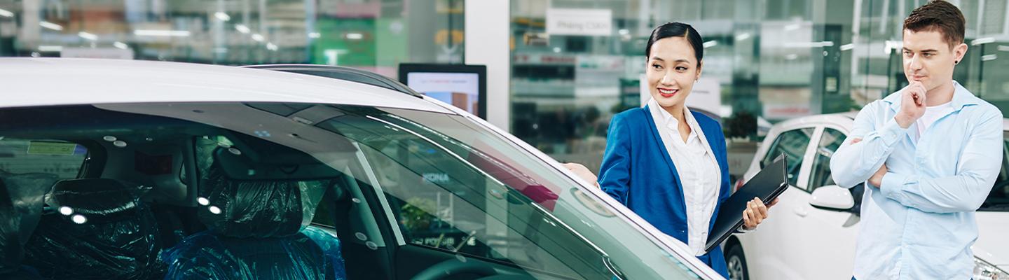 Sales person show customer a new car