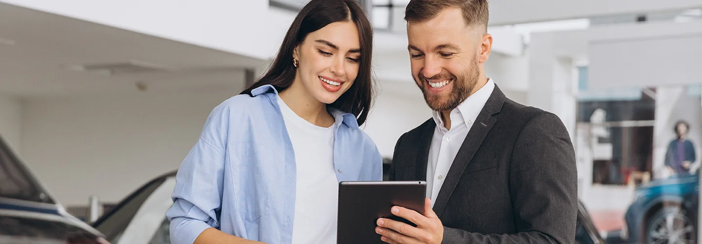 Car salesman showing a customer information about leasing a MINI on a tablet