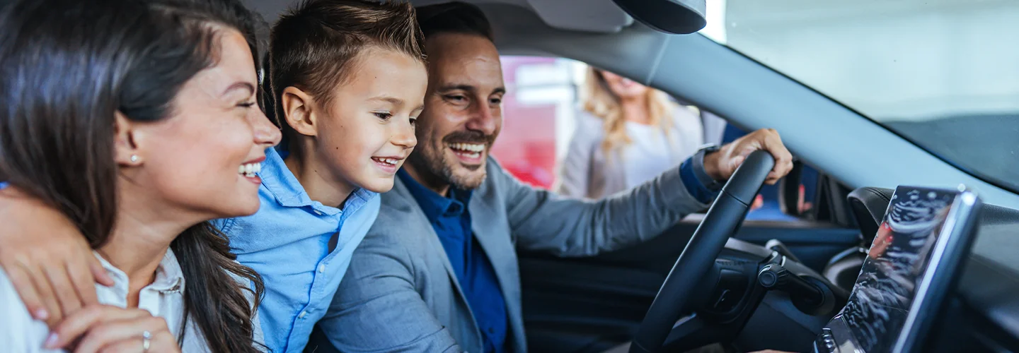 family of three in a new car very happy