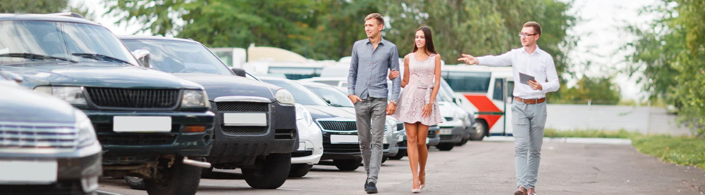couple discussing cars with salesperson