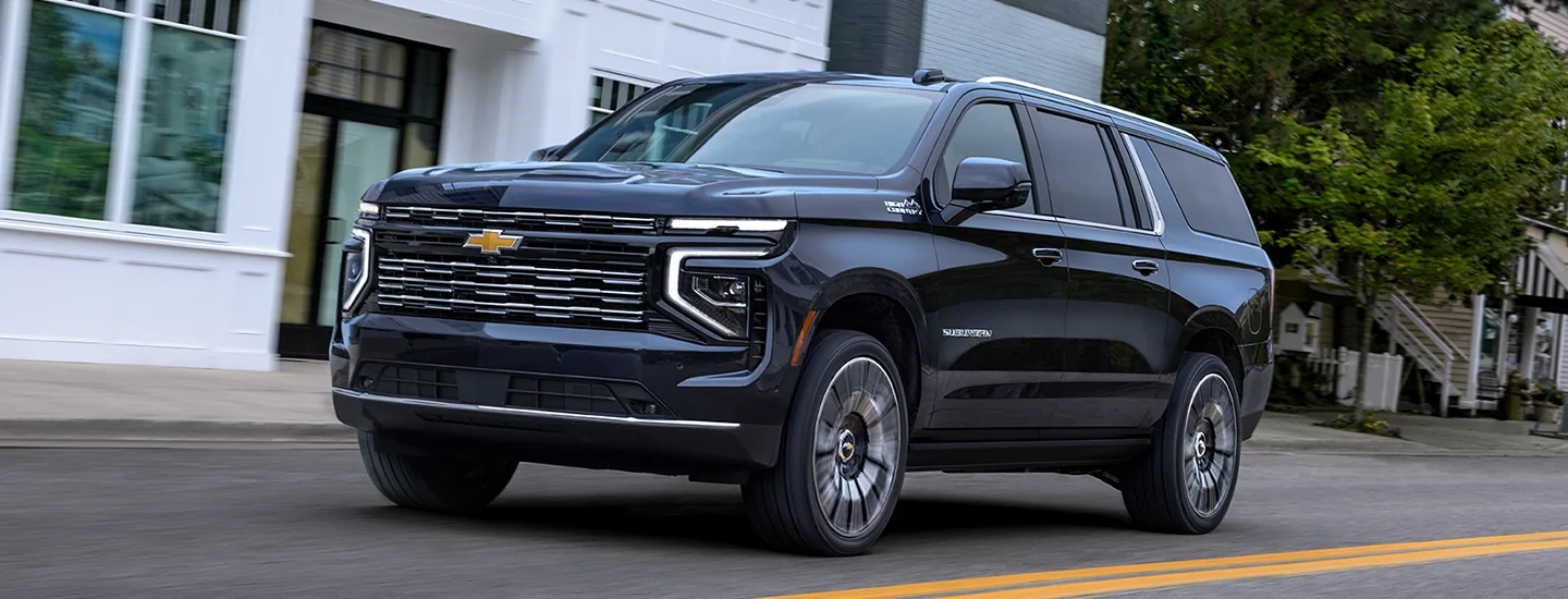 blue 2025 Chevrolet Suburban driving in town
