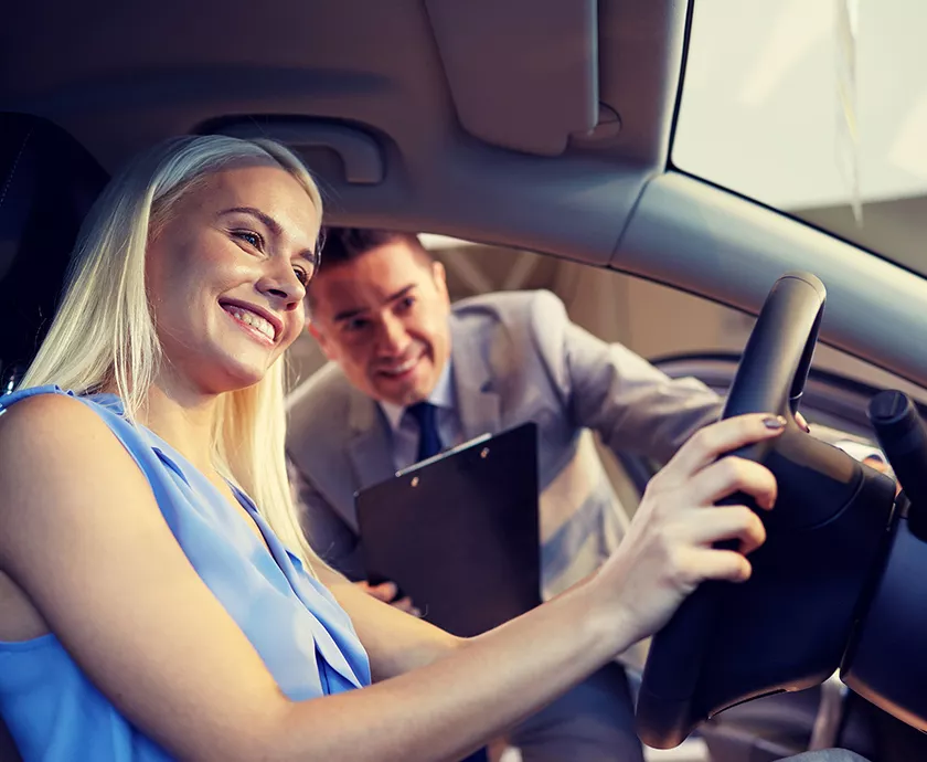 Sales person showing a women the inside of a 2027 RAM 1500