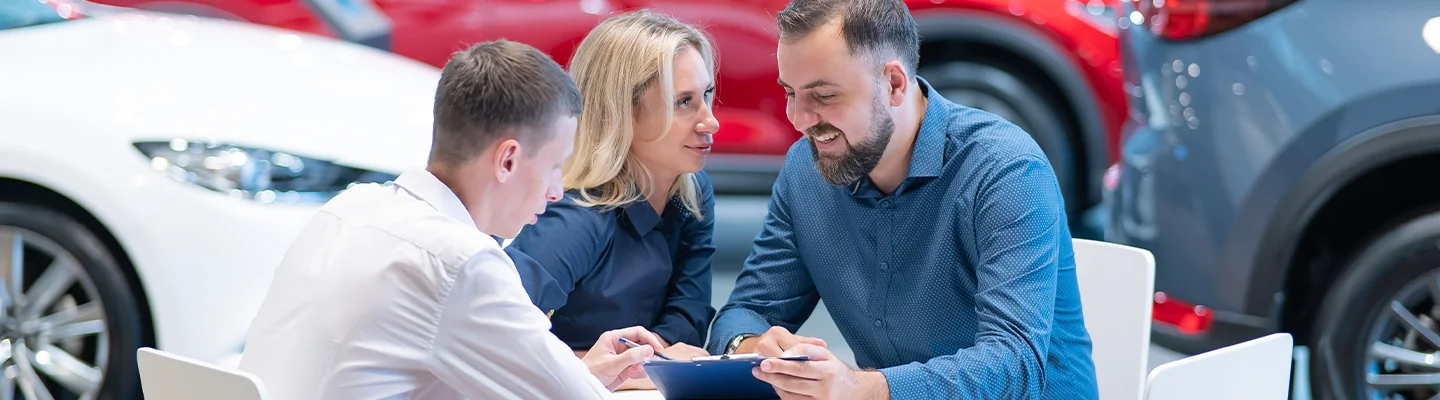 Buying or Leasing couple discussing with salesperson