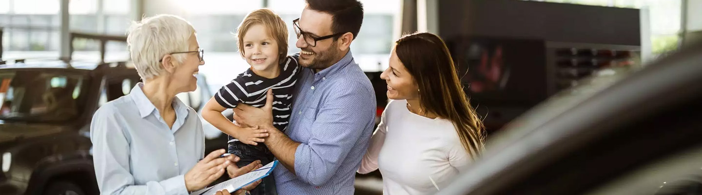 Family signing papers for there new car