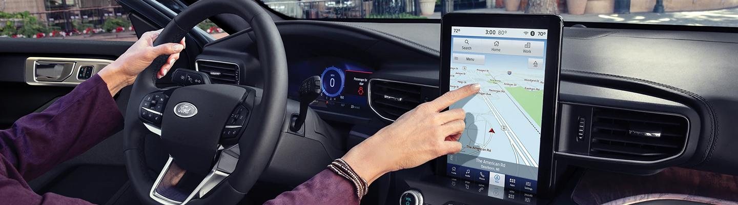 hand pointing at gps screen in car