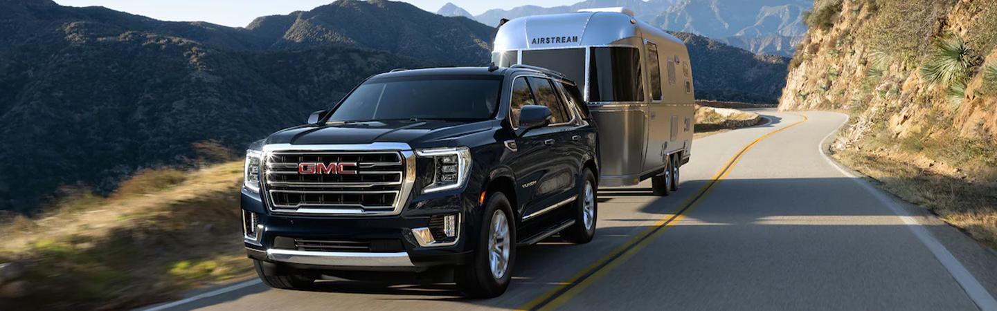 2021 GMC Yukon towing a trailer on a mountain road