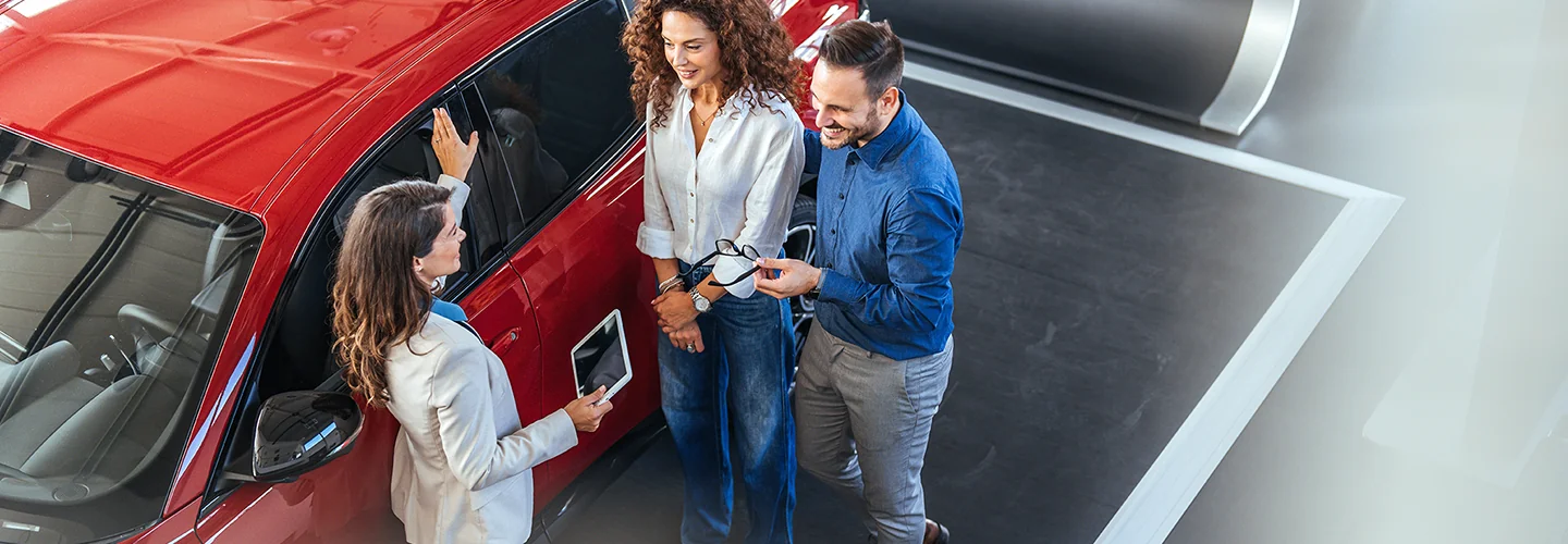 Salesperson showing a Kia to customers