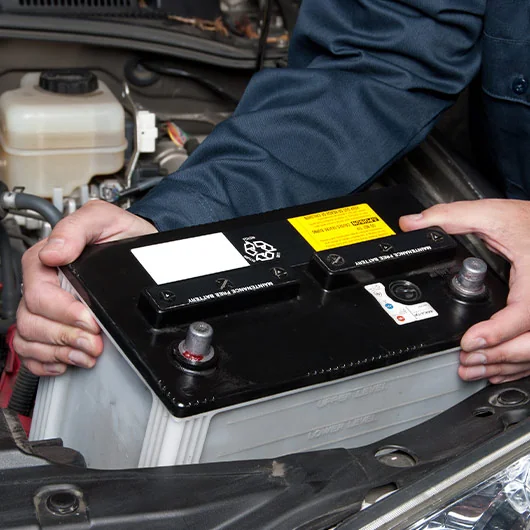 Ford Battery Service | Ford mechanic grabbing battery out of the car