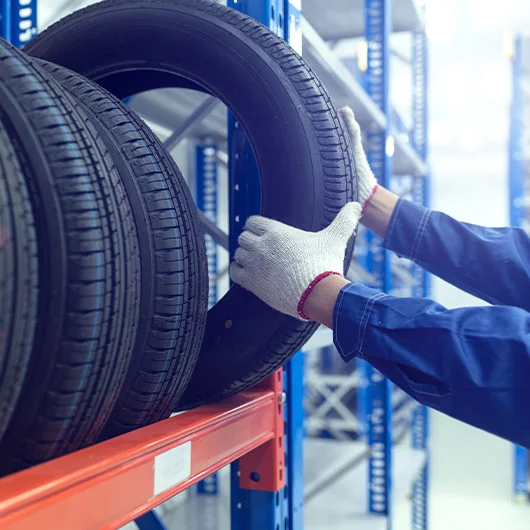 Ford Tire Service | Ford mechanic grabbing tire from the shelf