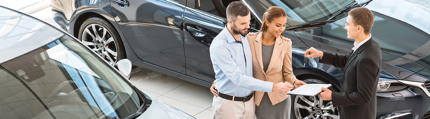 couple speaking with selsperson in the dealership