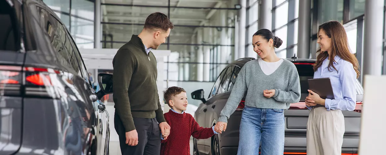 Sales advisor showing a first-time buyer a new BMW at a dealership