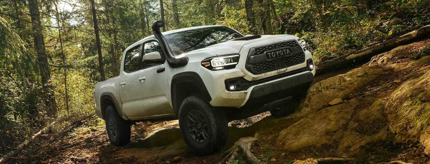 White 2020 Toyota Tacoma With Snorkel Driving On Rocks