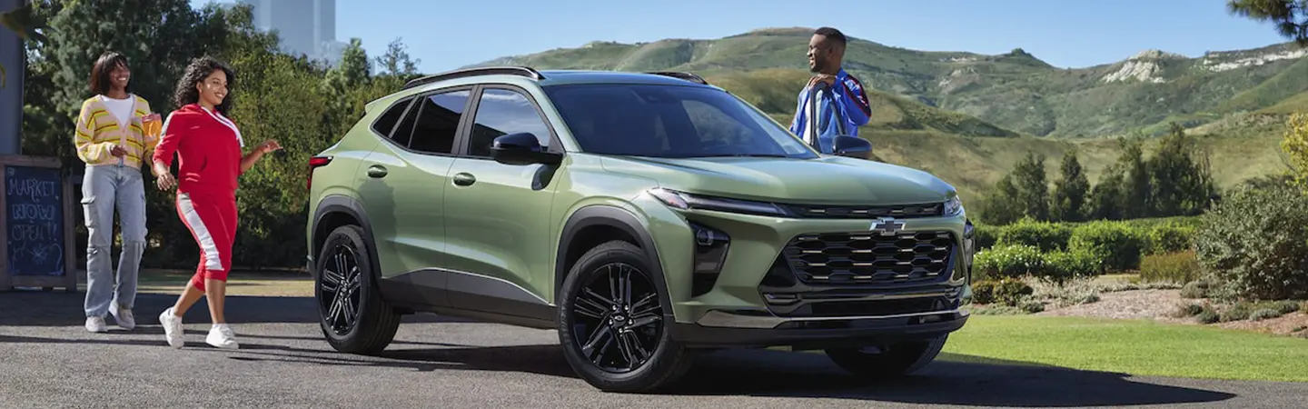 People getting into a parked green 2025 Chevrolet Trax