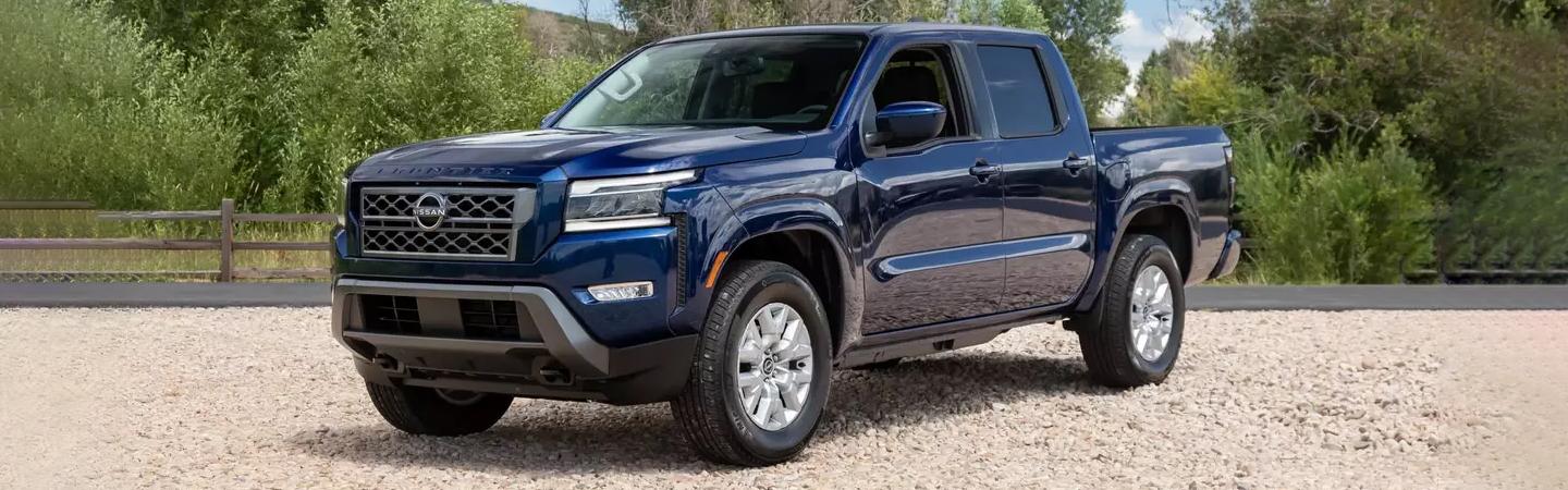 Blue 2022 Nissan Frontier parked on the dirt road
