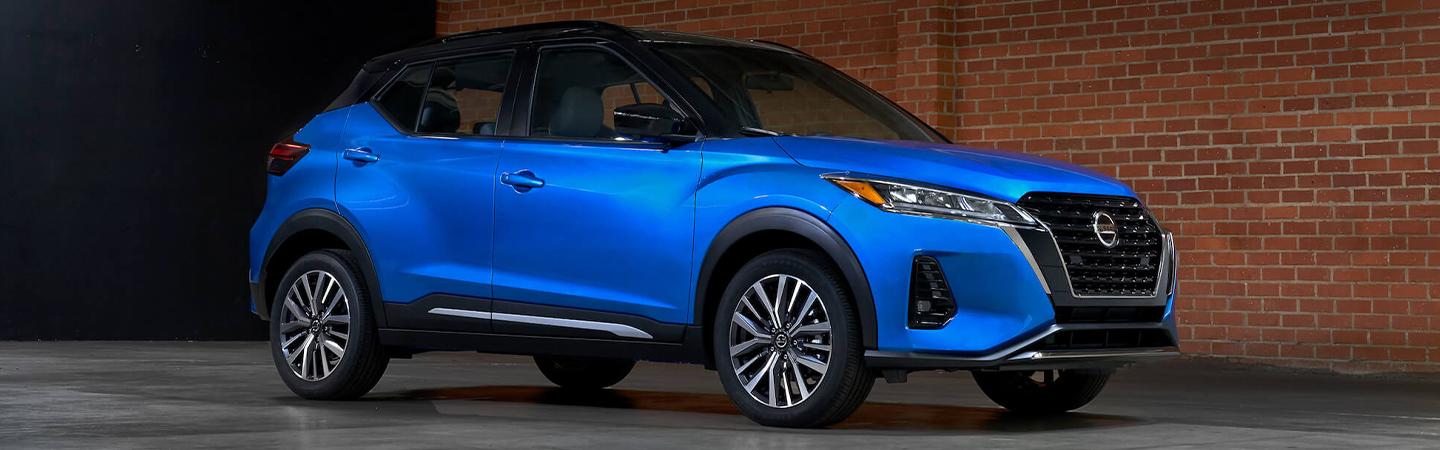 Blue 2021 Nissan Kicks parked next to a brick wall