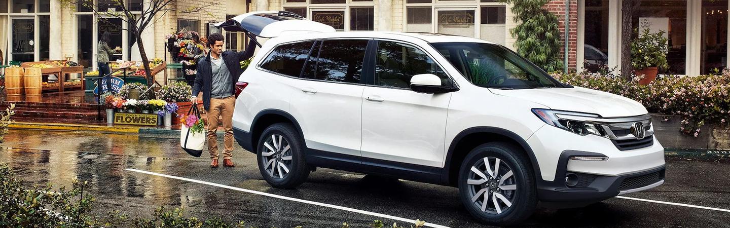 2022 Honda Pilot parked side view with man closing the trunk