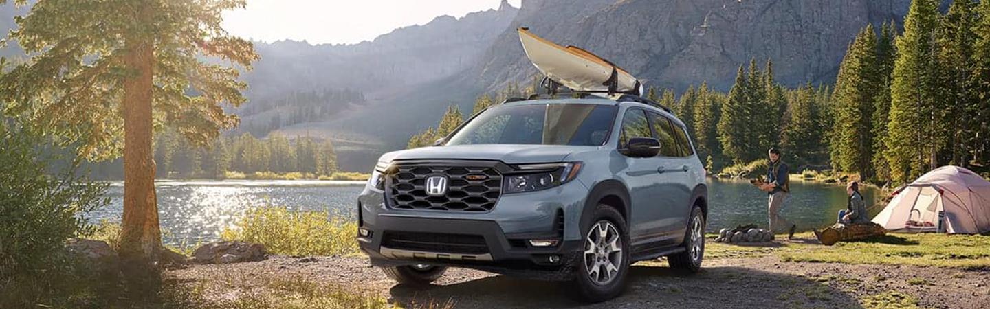 2022 Honda Passport with canoe on top rack by lake camping