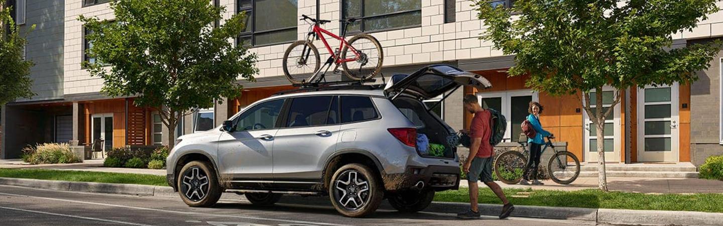 2022 Honda Passport with bike racked on top man loading at rear