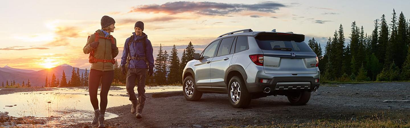 2022 Honda Passport parked by river couple leaving to go hiking