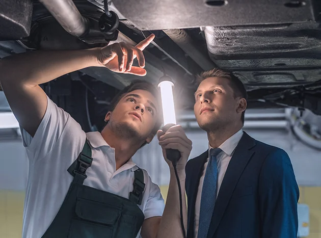 Service people checking out a problem under a car