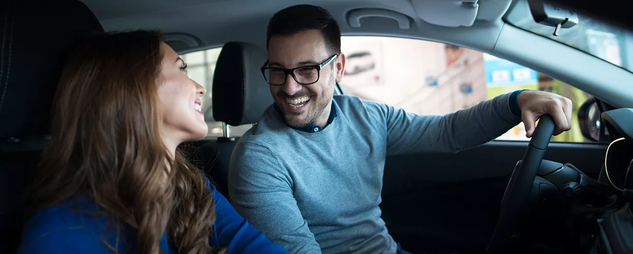 a couple sitting in a car smiling
