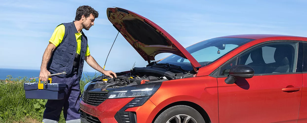 person with toolbox approaching a car with hood up waiting for repair
