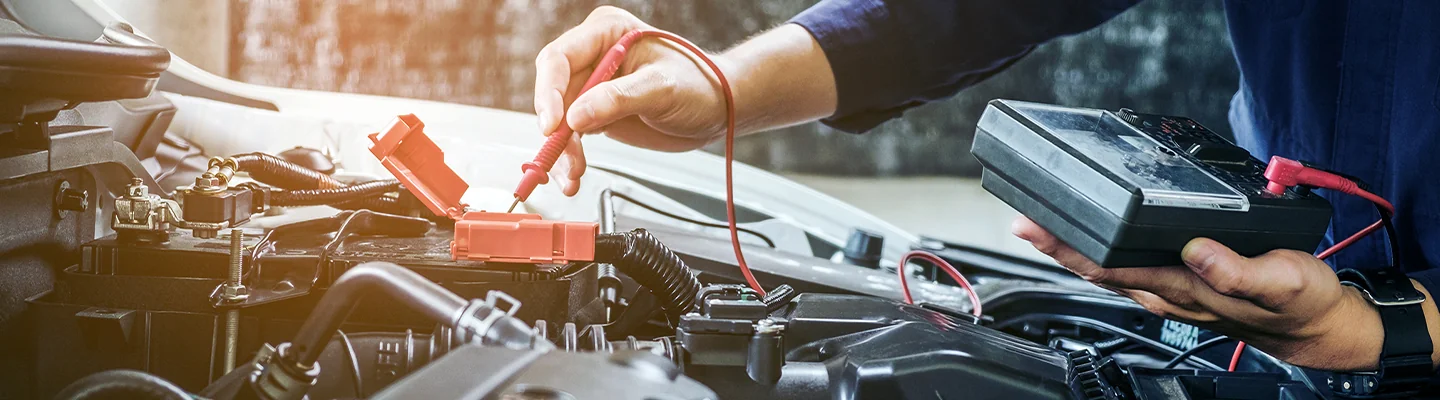 Service technician tests battery on a vehicle