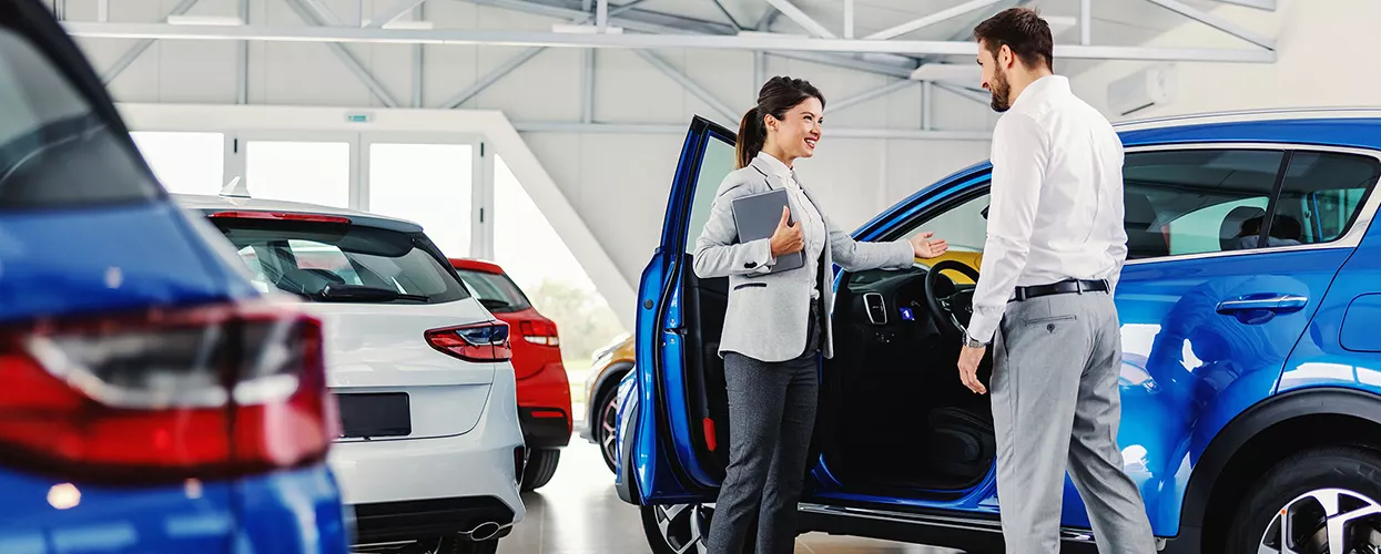 Car salesman showing a customer a new Subaru vehicle