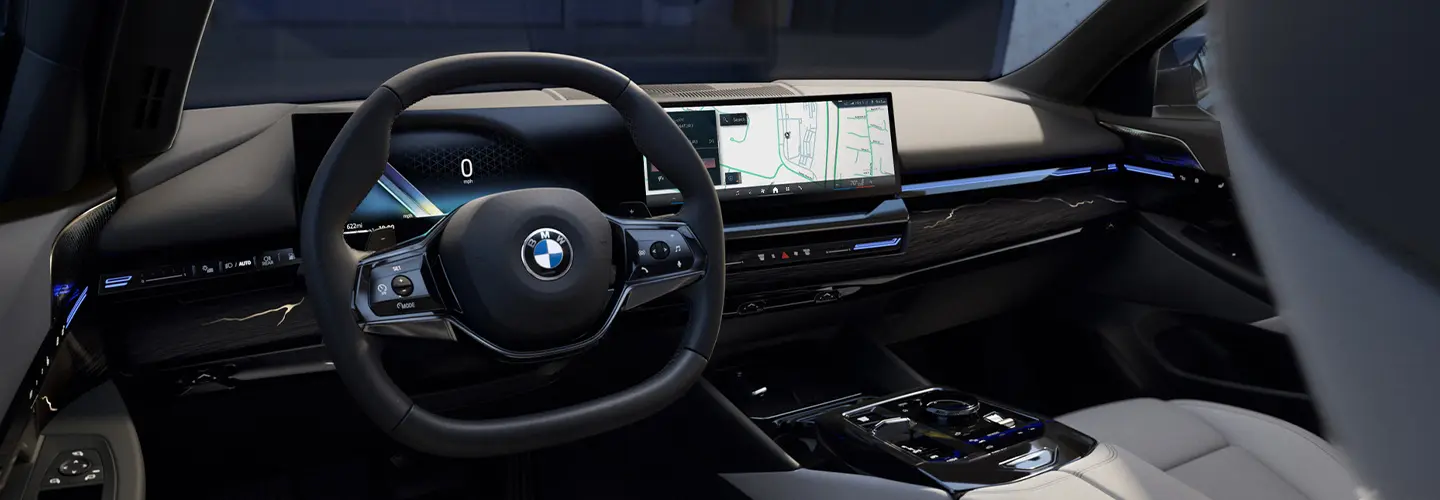 Interior view of the front seats and dashboard of a 2025 BMW 5 Series