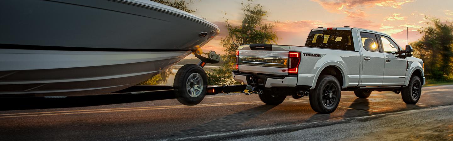 Rear view of a white Ford Super Duty truck towing a boat