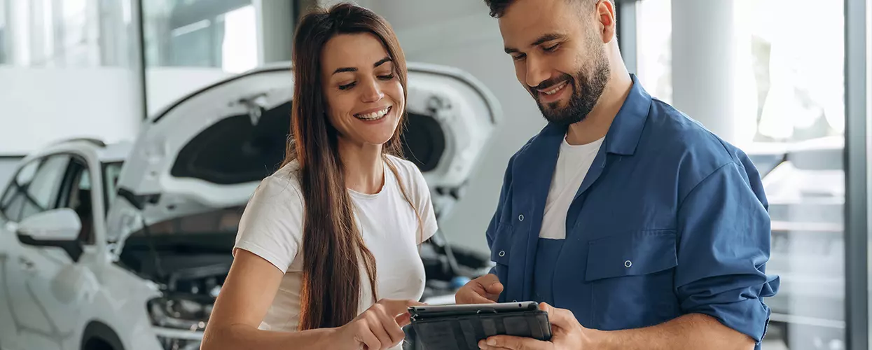 Service mechanic talking to a customer about her vehicle