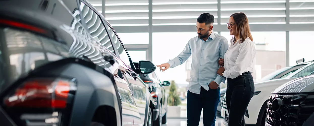 Couple looking at a new vehicle in a car dealership
