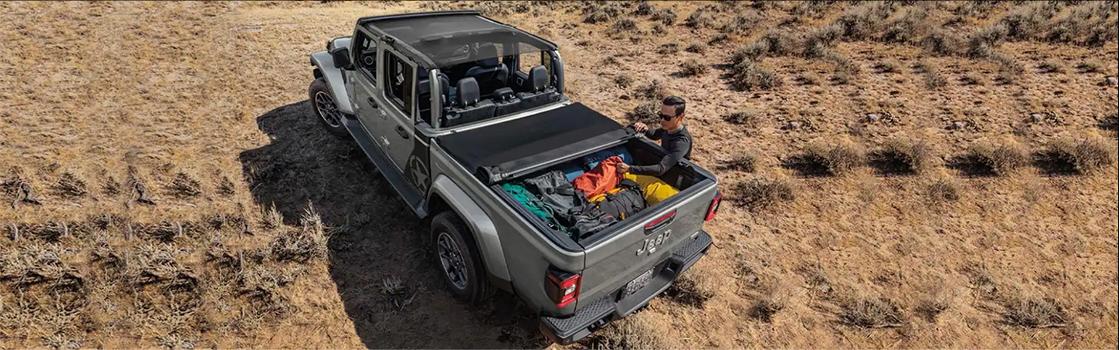 man taking gear out of his Jeep Gladiator
