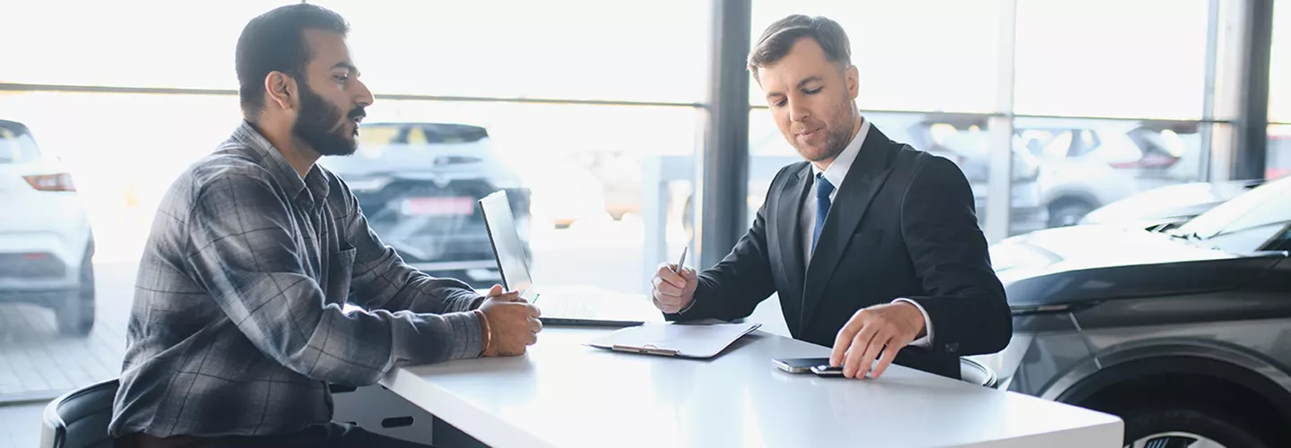 Car salesman talking with a customer about a contract