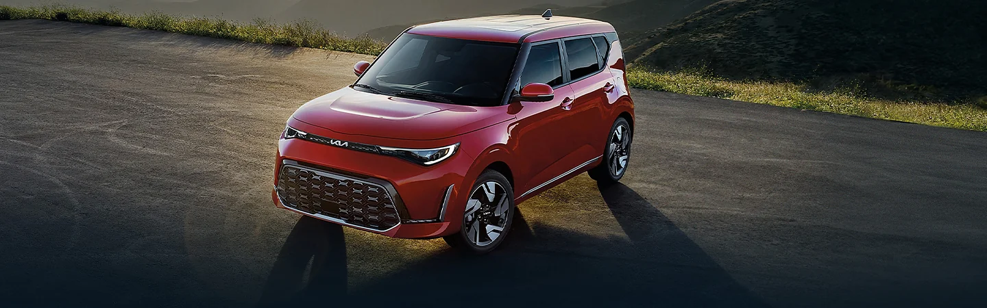 Front view of a parked red 2025 Kia Soul in the middle of nowhere