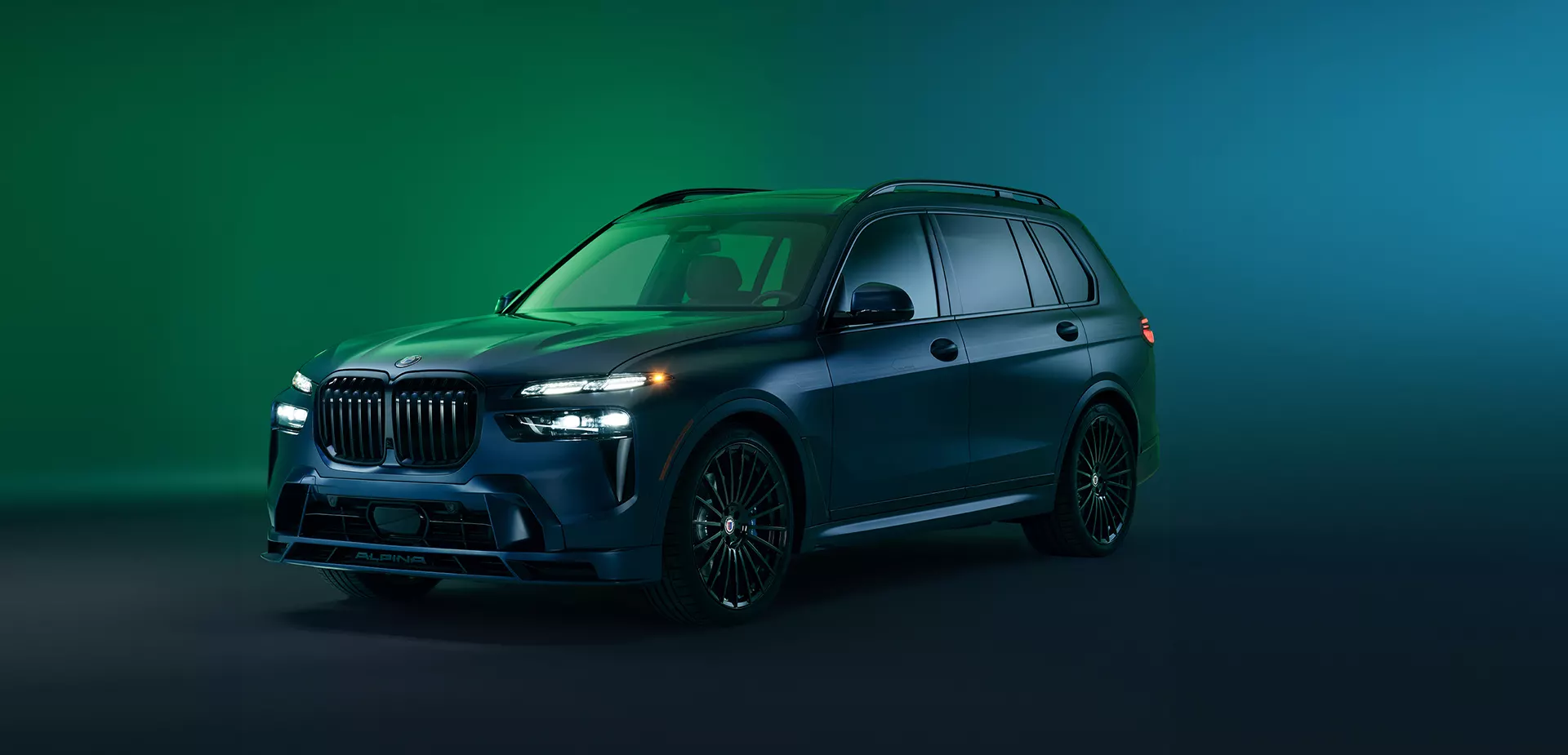 Front side view of a parked green blue 2027 BMW X7 in a green room