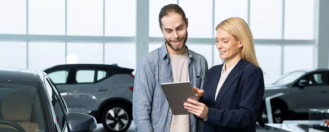 Car saleswoman talking to a customer in a car dealership