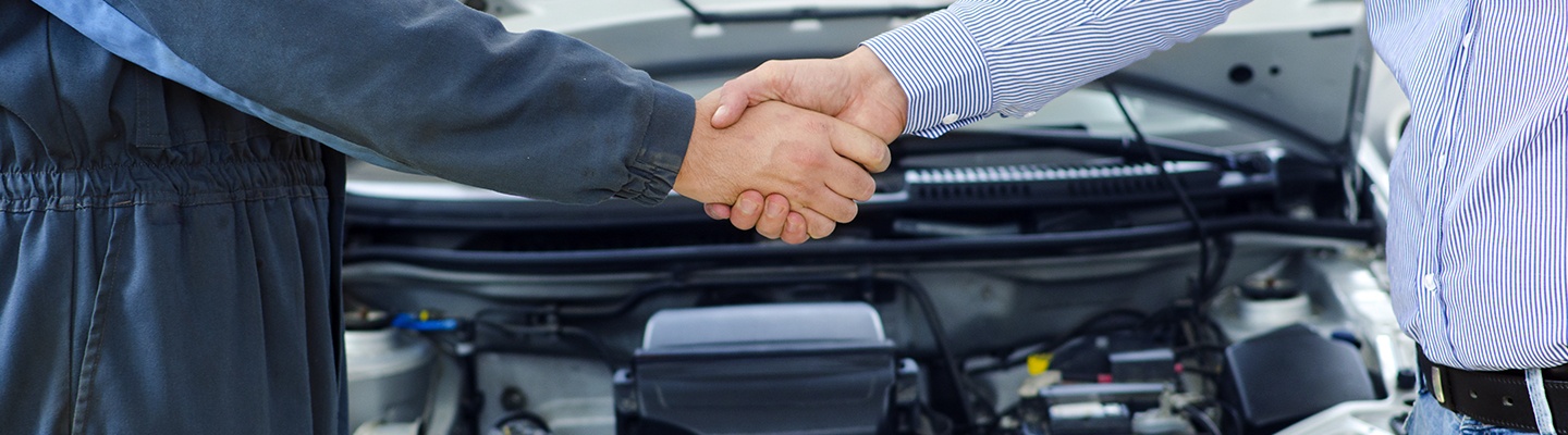  A dealership employee and customer shaking hands