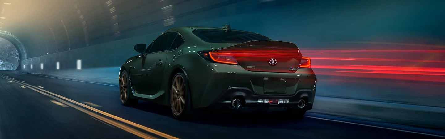 Rear view of 2025 Toyota GR86 driving at night through a tunnel