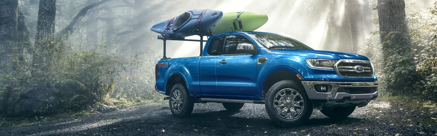 blue Ford Truck with Kayaks on top