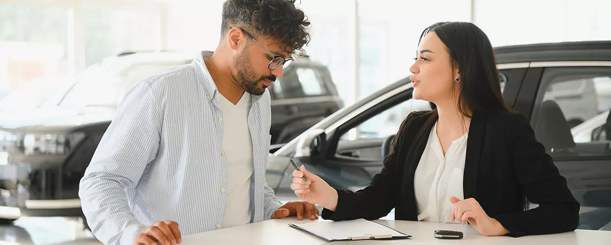 Car salesman talking to a customer about a contract