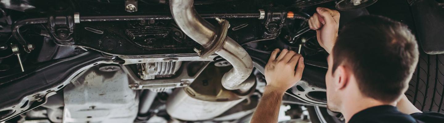 mechanic fixing transmission under a car