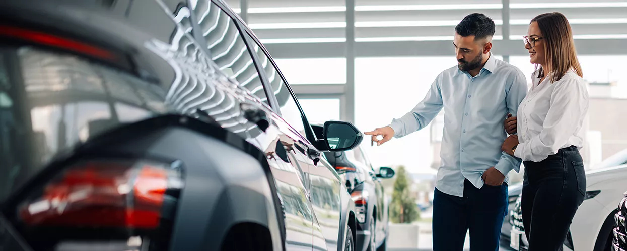 Couple looking through a car dealership