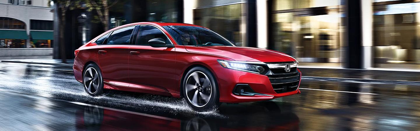 Red 2022 Honda Accord driving in rain through city