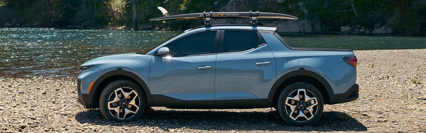2022 Hyundai Santa Cruz SE with surfboard on top at beach