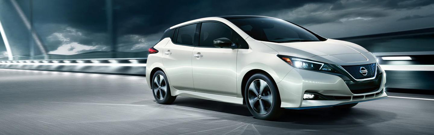 white 2022 Nissan Leaf driving on a bridge