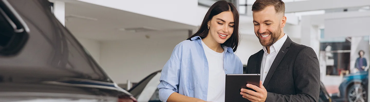 Car salesman showing information to a customer on a tablet